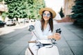 Young woman drinking takeaway coffee near her moped in the morning Royalty Free Stock Photo