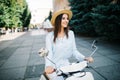 Young woman drinking takeaway coffee near her moped in the morning Royalty Free Stock Photo