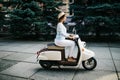 Young woman drinking takeaway coffee near her moped in the morning Royalty Free Stock Photo