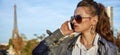 Young trendy woman speaking on smartphone near Eiffel tower Royalty Free Stock Photo