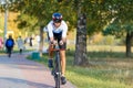 Young triathlete sportsman riding bicycle on road