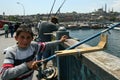 A young Turkish fisherman on Galata Bridge in Istanbul in Turkey.