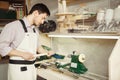 Young turner engages in wood carving on lathe for wood