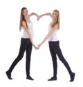 Young twins sisters making heart shape with arms