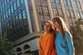 Young twins standing on the building background hugging and looking in the side