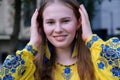 beautiful Ukrainian woman in a yellow-blue embroidered shirt looks into the frame smiles straightens close-up face