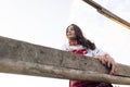 Young Ukrainian woman stands in traditional national embroidered shirt and skirt near wooden fence against sky background Royalty Free Stock Photo