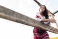 Young Ukrainian woman stands in traditional national embroidered shirt and skirt near wooden fence against sky background Royalty Free Stock Photo