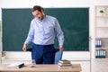 Young underpaid male teacher in the classroom