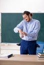 Young underpaid male teacher in the classroom