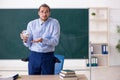 Young underpaid male teacher in the classroom