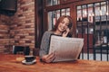 Woman reading a newspaper and talking on mobile phone Royalty Free Stock Photo