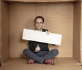 Young unemployed man holding a white board, a place for advertising, the idea of a cry for help Royalty Free Stock Photo