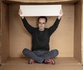 Young unemployed man holding a white board, a place for advertising, the idea of a cry for help Royalty Free Stock Photo