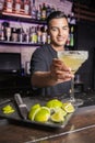 Young unfocused mixologist leaving a margarita cocktail on the bar of a pub Royalty Free Stock Photo