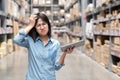 Young unhappy asian woman, auditor or employee looking and feeling confused in warehouse store. Portrait of young girl scratching Royalty Free Stock Photo