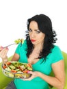 Young Unhappy Scowling Woman Eating a Fresh Crisp Mixed Garden Salad Royalty Free Stock Photo
