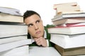 Young unhappy student with stacked books