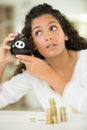 Young unhappy woman emptying piggybank savings