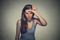 Young unhappy woman giving loser sign on forehead Royalty Free Stock Photo