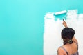 Young unidentifiable Asian woman painting wall with paint roller Royalty Free Stock Photo