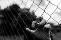 Young unidentifiable teenage boy holding the wired garden at the correctional institute in black and white, conceptual image of ju Royalty Free Stock Photo