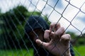 Young unidentifiable teenage boy holding the wired garden at the correctional institute Royalty Free Stock Photo