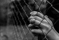 Young unidentifiable teenage boy holding the wired garden  praying at the correctional institute Royalty Free Stock Photo