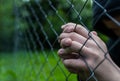 Young unidentifiable teenage boy holding the wired garden  praying at the correctional institute Royalty Free Stock Photo