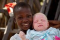 Young unidentified young black boy holding albino child in shade