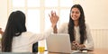 Young university student tutoring their lesson with using a computer laptop while sitting together at wood working desk. Royalty Free Stock Photo