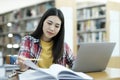 Young university student using laptop for online learning, searching and learning at library. Royalty Free Stock Photo
