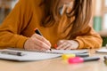 Young unrecognisable female college student in class, taking notes and using highlighter. Focused student in classroom. Royalty Free Stock Photo