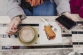 Young unrecognizable caucasian woman enjoying a cup of coffee and a piece of cake in a terrace with friends. Lifestyle outdoors. Royalty Free Stock Photo