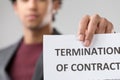 young unrecognizable man presents 'TERMINATION OF CONTRACT' noti