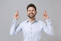 Young unshaven business man in light shirt posing isolated on grey background. Achievement career wealth business