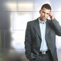 Young unsure businessman standing in front of wall