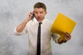 Young upset and angry businessman talking on mobile phone in stress yelling overwhelmed facing problem at office isolated on Royalty Free Stock Photo