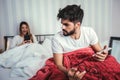 Young upset couple lying separate in a bed