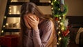 Young upset woman crying on wooden stairs being left alone on Christmas. Negative emotions, depression and solitude on