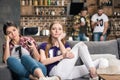 Young upset women sitting on sofa