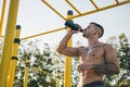 Young urban athlete drinking water at a calisthenics gym outdoor Royalty Free Stock Photo