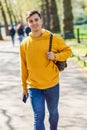 Young urban man using smartphone walking in street in an urban park in London. Royalty Free Stock Photo