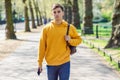 Young urban man using smartphone walking in street in an urban park in London. Royalty Free Stock Photo