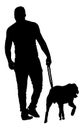 Young urban man walking dog vector silhouette. Back view boy with guardian dog. Royalty Free Stock Photo
