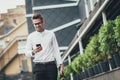 Young urban professional man using smart phone. Businessman holding mobile smartphone using app texting sms message Royalty Free Stock Photo