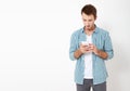 Attractive man with short dark hair chatting or typing text message using cell phone isolated over white background Royalty Free Stock Photo