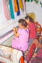 Young Uzbek girls weave carpet