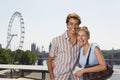 Young vacationing couple posing by Thames River portrait