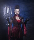 A young vampire lady in a dress holding candles Royalty Free Stock Photo